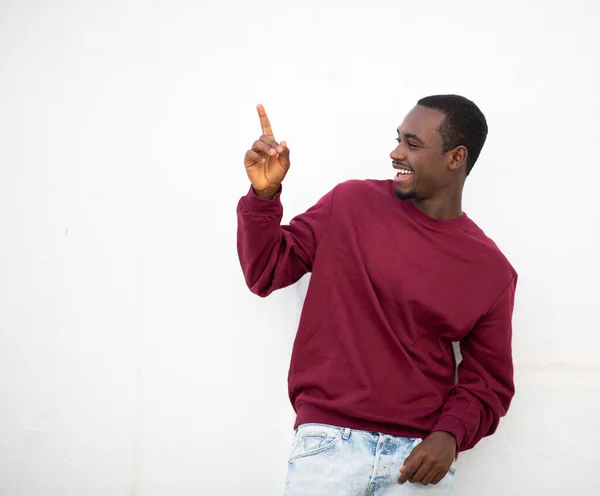幸せな若いアフリカ人男性の肖像画を指摘し 白い壁に対して笑顔 — ストック写真