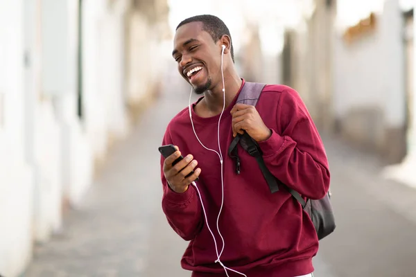 Cep Telefonuyla Gülümseyen Kulaklıkla Müzik Dinleyen Afrikalı Bir Adamın Portresi — Stok fotoğraf