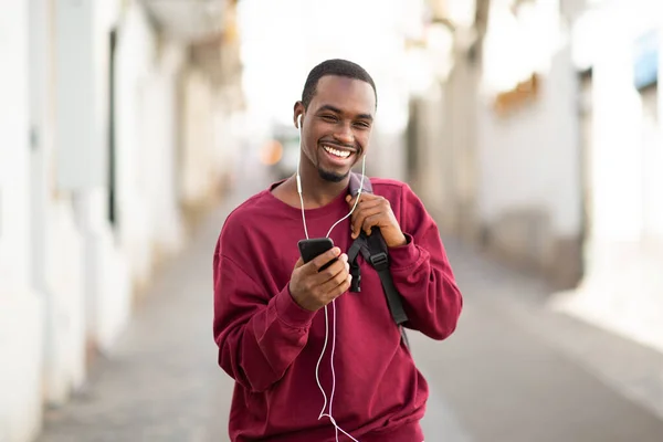Portret Przystojnego Młodego Czarnego Faceta Telefonem Komórkowym Słuchającego Muzyki Słuchawkami — Zdjęcie stockowe