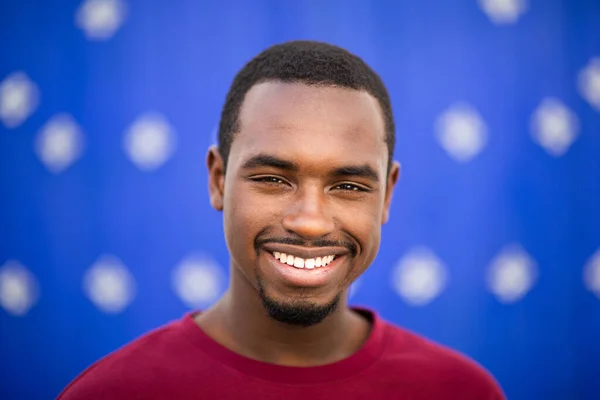 年轻快乐的非洲裔美国人在蓝色背景下微笑的肖像 — 图库照片