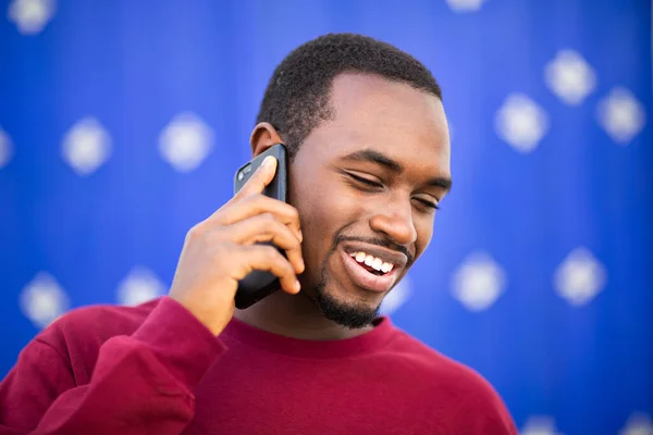 Närbild Porträtt Glad Afrikansk Man Talar Mobiltelefon Mot Blå Bakgrund — Stockfoto