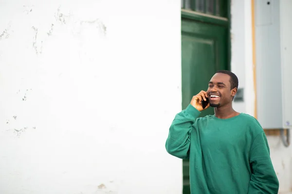 幸せな若いアフリカ系アメリカ人の男の肖像携帯電話で話して外を歩く — ストック写真