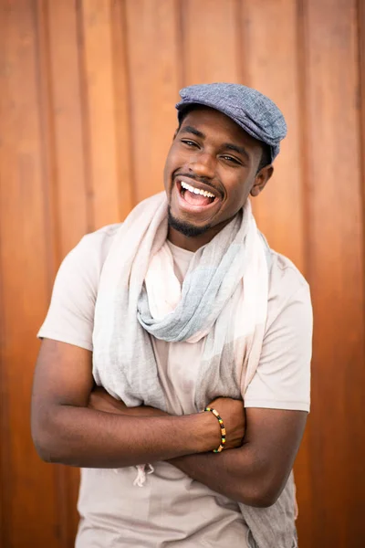Portrait Laughing Young African American Man Cap Scarf Wooden Background — Stock Photo, Image