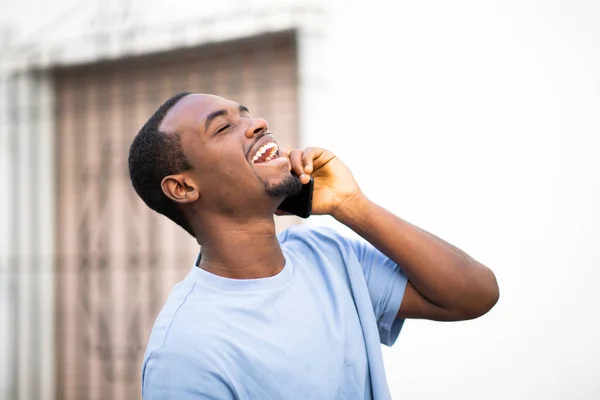 Portret Śmiejącego Się Młodego Czarnego Mężczyzny Wychodzącego Zewnątrz Rozmawiającego Przez — Zdjęcie stockowe