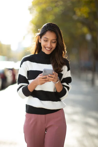 Portrét Usměvavé Mladé Ženy Kráčející Mobilním Telefonem Ruce Venku — Stock fotografie