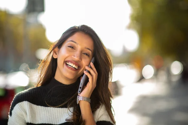 美しい若い女性の肖像笑顔と街の屋外で携帯電話と話す — ストック写真