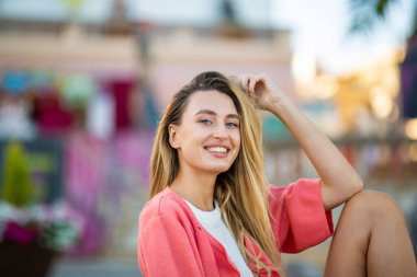 Tarz sahibi beyaz bir kadının portresi. Açık havada el saçı ile rahatlıyor.