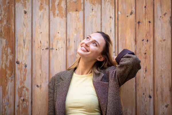 Stylish Young Lady Coat Looking Smiling While Leaning Wooden Door — Stock Photo, Image
