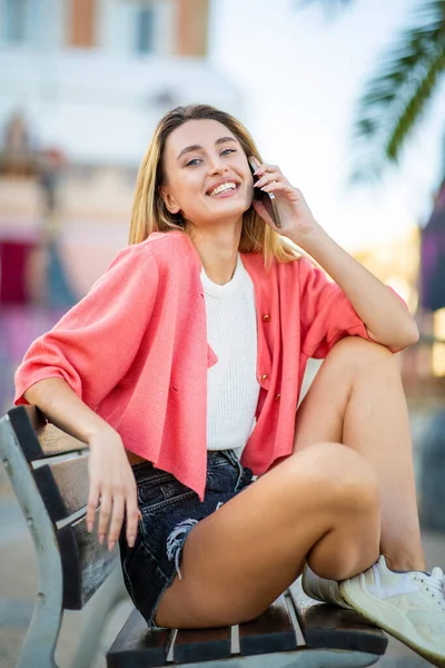 Hermosa Joven Sonriente Mujer Hablando Teléfono Móvil Mientras Está Sentado — Foto de Stock