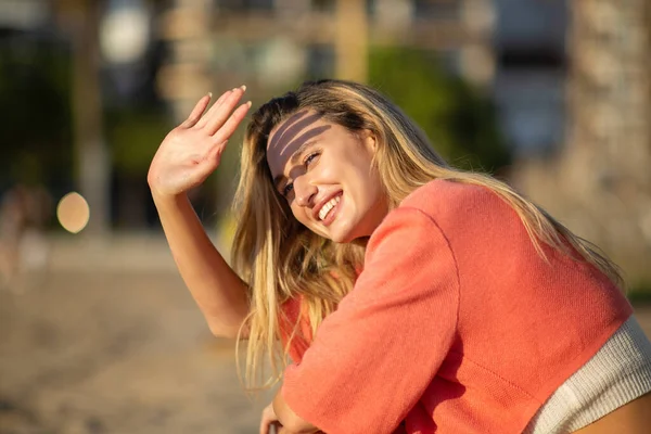 Atractiva Joven Mujer Levantando Mano Para Sombrear Rostro Del Sol —  Fotos de Stock