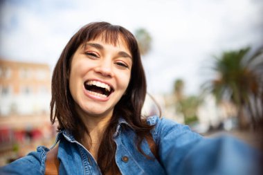 Dışarıdaki gülen Latin kadının selfie portresi.