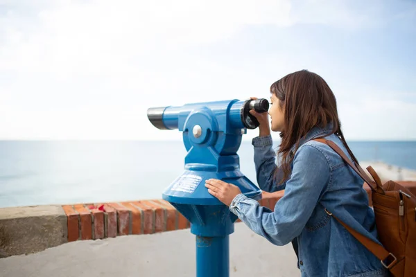 利用双目望远镜观看大海的女性游客的侧视图 — 图库照片