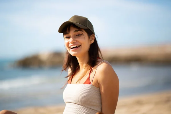 Plajda Oturmuş Kameraya Bakıp Gülen Neşeli Genç Bir Kadının Portresi — Stok fotoğraf