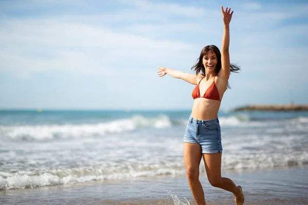 Portrait Cheerful Young Woman Bikini Top Running Beach Arms Raised — Stock Photo, Image