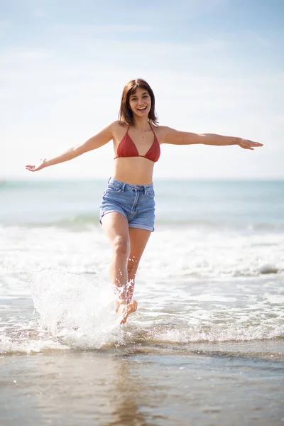 Portret Wesołej Młodej Kobiety Spacerującej Plaży Wyciągniętymi Ramionami — Zdjęcie stockowe