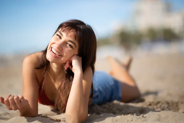 Portret Wesołej Młodej Kobiety Leżącej Piaszczystej Plaży Patrzącej Kamerę Śmiejącej — Zdjęcie stockowe
