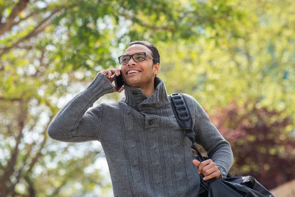 Portrét Pohledného Mladého Muže Taškou Kráčející Ven Mluvící Mobilním Telefonu — Stock fotografie