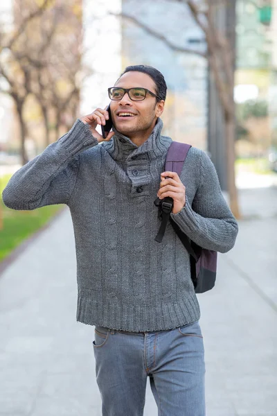 全市年轻英俊的男女混血男子拿着手提包在手机上交谈的画像 — 图库照片