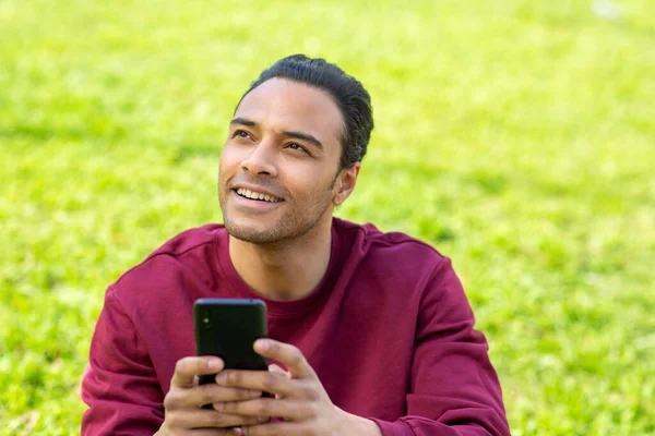 Портрет Красивого Молодого Чернокожего Мужчины Сидящего Парке Мобильным Телефоном Который — стоковое фото