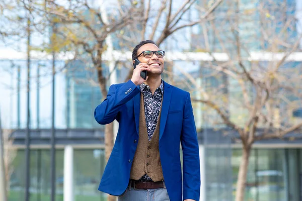 街の外を歩いている間に携帯電話で話しているハンサムな若いビジネスマンの肖像 — ストック写真