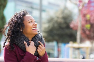 Güzel bir Afrikalı kadının portresi. Kış eşarplı. Gözlerini kaçırıyor ve gülümsüyor.