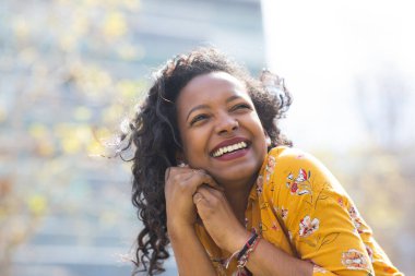 Güzel, genç bir Afrikalı kadının portresi. Başka tarafa bakıyor ve gülümsüyor.