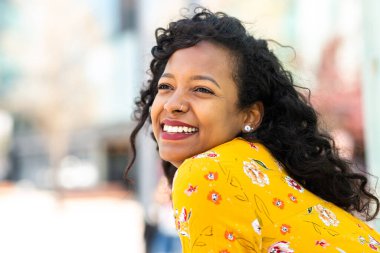 Uzaklara bakıp gülümseyen Afrikalı güzel bir kadının portresini yakından çek.