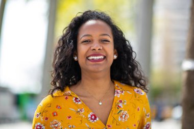 Dışarıda gülümseyen güzel genç Afrikalı kadın portresi kapatın