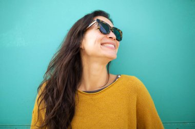 Yeşil duvara yaslanmış güzel Asyalı kadın modelin yakın plan portresi.