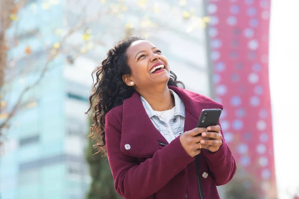 Porträtt Glad Ung Afrikansk Amerikansk Kvinna Vinterrock Håller Mobiltelefon Utanför — Stockfoto