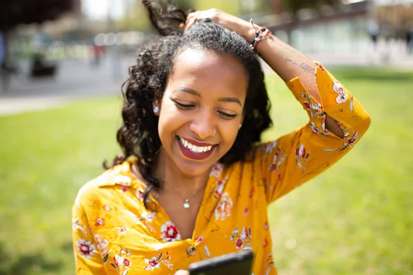 Närbild Porträtt Glad Ung Afrikansk Kvinna Tittar Mobiltelefon Och Ler — Stockfoto