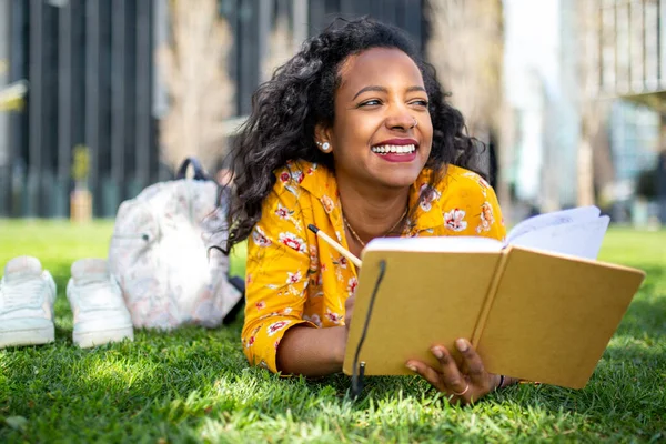 Mutlu Afro Amerikalı Bir Kadının Portresi Parkta Çimlere Uzanmış Kitap — Stok fotoğraf