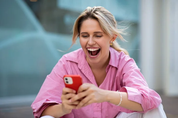 Retrato Una Joven Excitada Mirando Teléfono Móvil Riendo Sentada Afuera — Foto de Stock