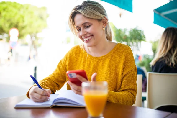 Портрет Счастливой Молодой Женщины Мобильным Телефоном Сидящей Возле Кафе Пишущей — стоковое фото