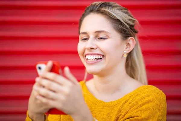 Retrato Cerca Una Joven Sonriente Mirando Teléfono Móvil Contra Obturador —  Fotos de Stock