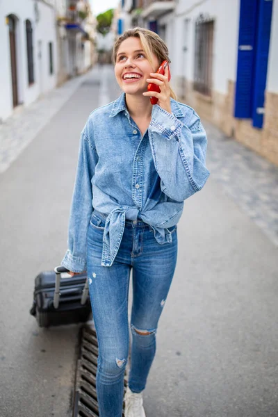 美しい若い女性の肖像旅行バッグと街の外で携帯電話を使用して歩く — ストック写真