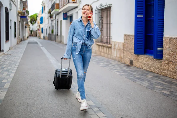 stock image Full length portrait of happy young woman walking and talking with cellphone and bag