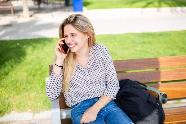 Portrait Cheerful Young Woman Sitting Park Bench Talking Mobile Phone — Stock Photo, Image