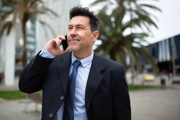 成熟したビジネスマンの密接な肖像市の外に立って電話をかける — ストック写真