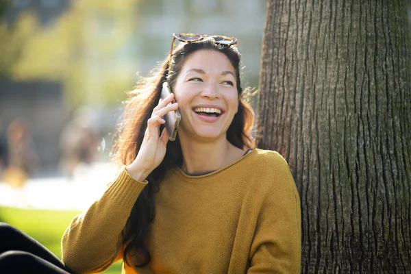 Портрет Веселой Молодой Азиатской Женщины Сидящей Дереве Разговаривающей Мобильному Телефону — стоковое фото