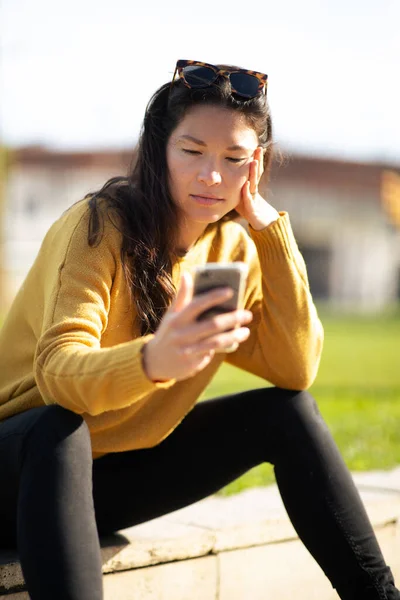 Портрет Китайской Женщины Сидящей Снаружи Смотрящей Свой Мобильный Телефон — стоковое фото
