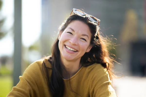 魅力的な中国人女性のクローズアップポートレートカメラを見て外に座って笑顔 — ストック写真
