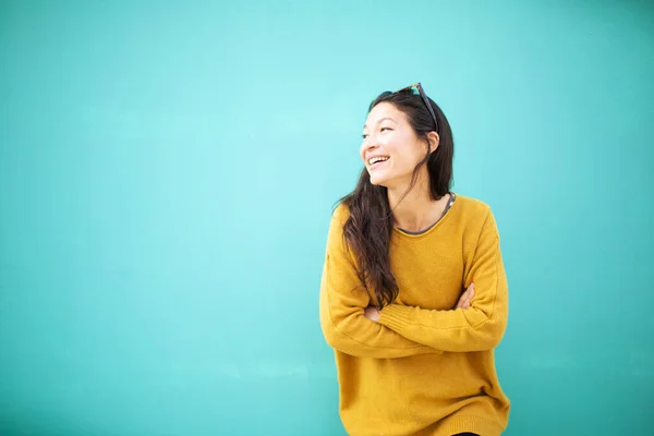 Kollarını Kavuşturmuş Yeşil Duvara Bakıp Gülümseyen Mutlu Genç Bir Kadının — Stok fotoğraf