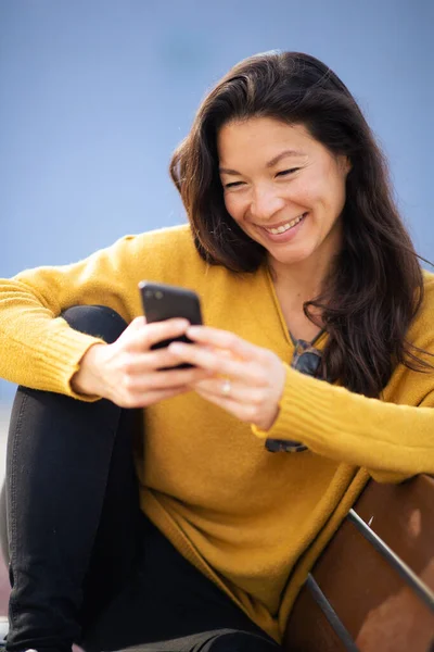 Портрет Красивой Молодой Азиатки Сидящей Скамейке Пользующейся Мобильным Телефоном — стоковое фото