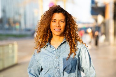 Kentin dışında kameraya bakan zarif İspanyol kadının yakın portresi.