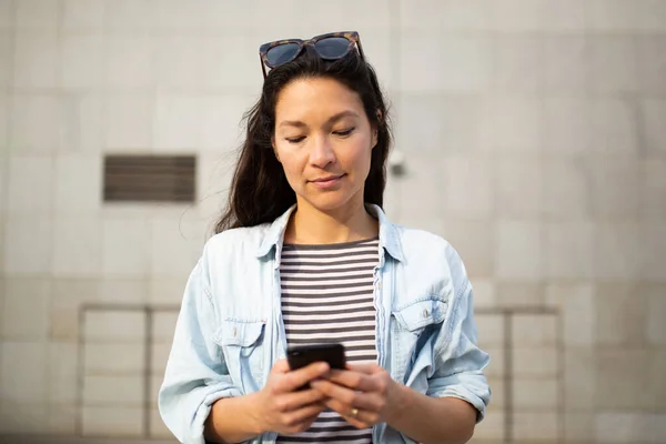 街の外の携帯電話でテキストメッセージを読む美しい若いアジアの女性のクローズアップ肖像画 — ストック写真