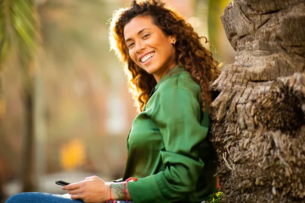 Portrét Šťastné Mladé Ženy Chytrým Telefonem Opírající Strom Venku Parku — Stock fotografie
