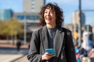 Şehirde cep telefonlu güzel bir kadının portresi.