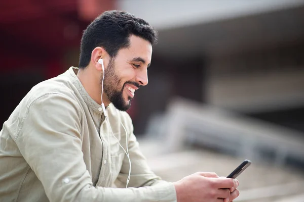 Açık Havada Cep Telefonuyla Müzik Dinleyen Gülümseyen Arap Adamın Yan — Stok fotoğraf