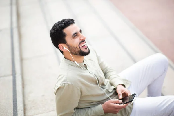 Ritratto Uomo Arabo Sorridente Seduto Fuori Che Diverte Ascoltare Musica — Foto Stock